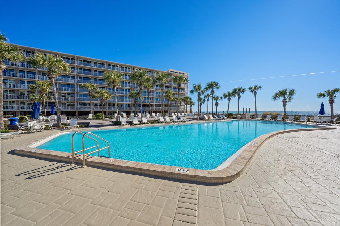 Palm-lined pool with resort building behind