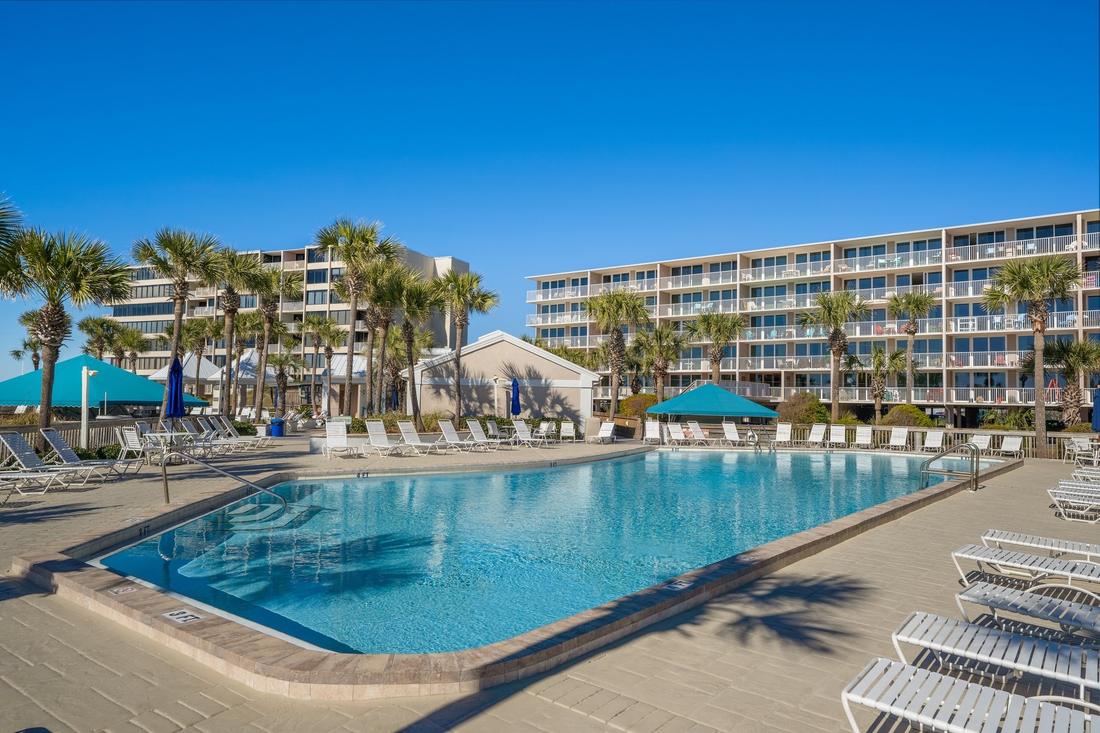 Pool and loungers beside a Dunes of Panama building