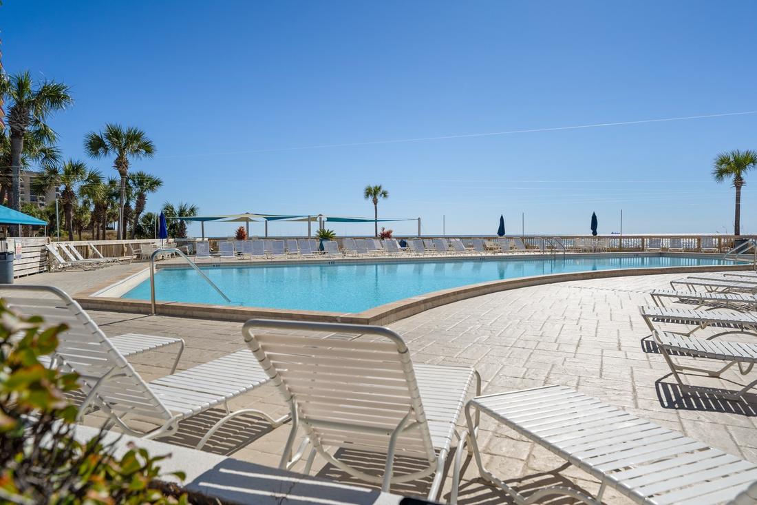 Pool area with shade canopy and loungers