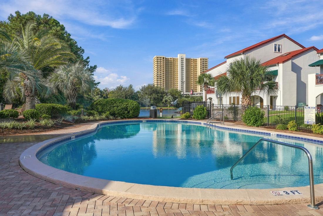 Outdoor pool with palms and Gulf-front towers beyond